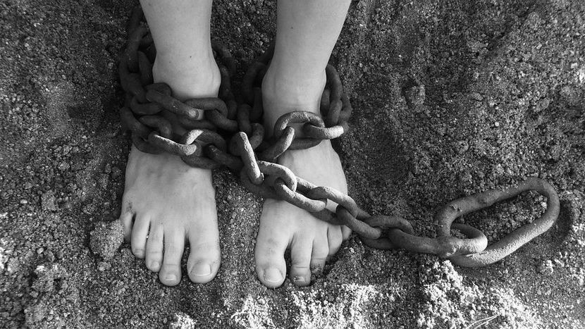 stopy dziecka skute kajdanami z łańcucha