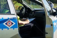 Policjant drogówki w radiowozie wypełnia dokumentację