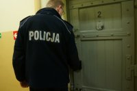 Policjant zamykający pokój w pomieszczeniu dla osób zatrzymanych