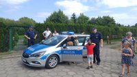 policjanci pokazują dzieciom radiowóz