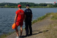 ratownik z policjantka obserwują jezioro