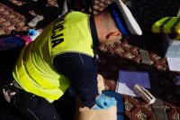 policjant pokazuje jak udzielać pierwszej pomocy