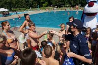 policjantka na basenie rozdaje odblaski dzieciom