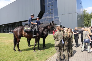 Policjanci na koniach odpowiadający na pytania uczniów klas mundurowych
