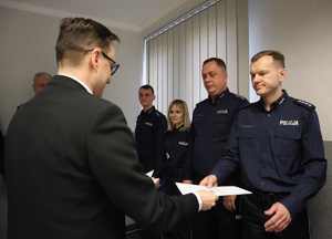 Prokurator Rejonowy gratuluje wręcza podziękowania policjantowi